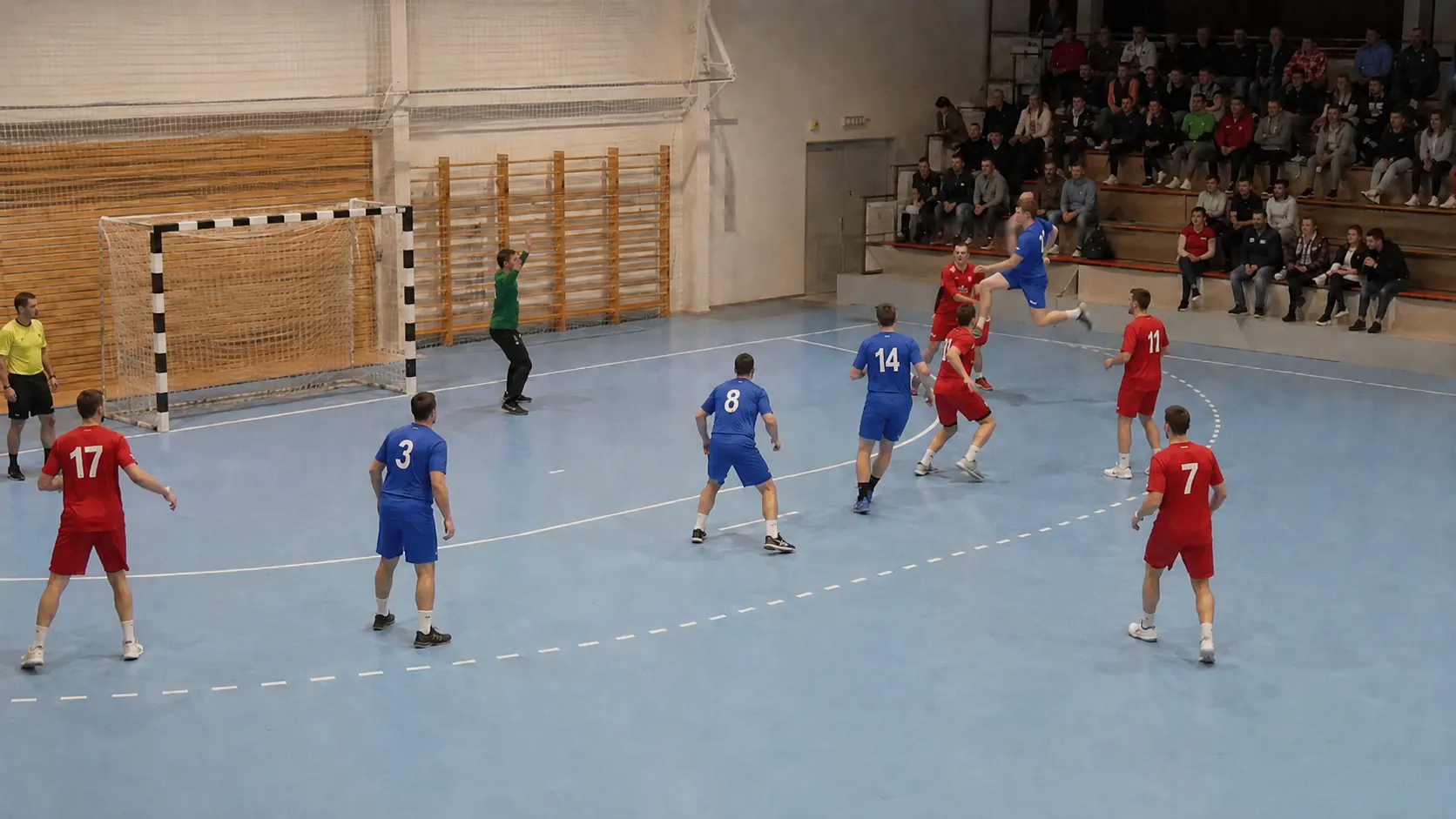 Two club handball teams contesting a shot at the six-metre line during an indoor match