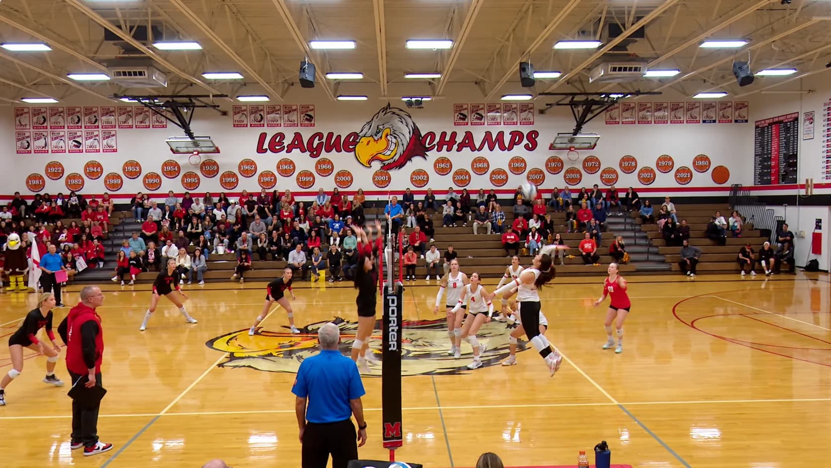 Two club volleyball teams at the net during an indoor match
